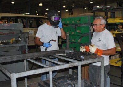 Person wearing welding mask accompanied another person